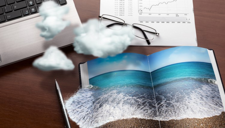 Office table in clouds with the sea on the notebook. Vacation co